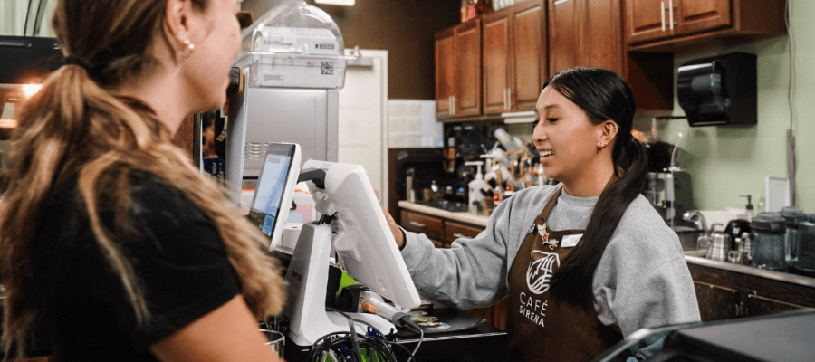 A student working at a cash register at the Cafe Sirena