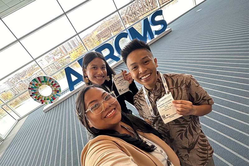 Photo of three students in a conference center