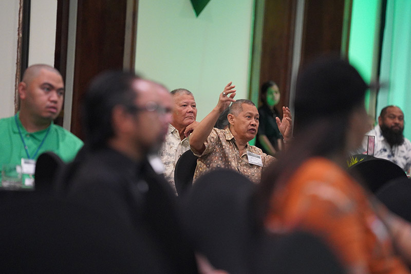 Photo of a man speaking from the audience at a conference