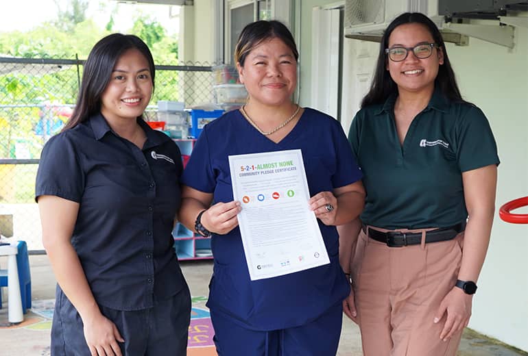 Katrina Macasaquit, Delilah Charfauros, and Iesha Ibanez pose for photo holding 5-2-1 Almost None pledge