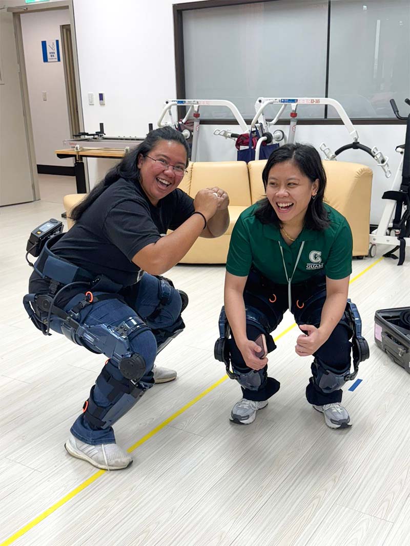 Kateri Taimanao and McEllie Garcia test out the Keeogo Exoskeleton, a walking assistive device, at the National Taipei University of Nursing & Health Sciences. two students trying on assistive technology for farmers