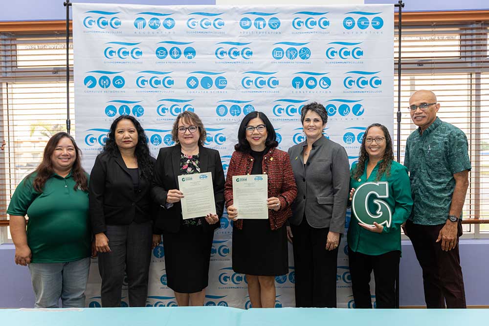 (From left) Leslie Aquino, chair of UOG’s Division of Mathematics and Computer Science; Gina Tudela, vice president of academic affairs for GCC; Mary Okada, president of GCC; Anita Borja Enriquez, president of UOG; Rachael T. Leon Guerrro, dean of UOG’s College of Natural & Applied Sciences; Marlena Pangelinan, vice provost for institutional effectiveness for UOG; and Maika Vuki, interim associate dean for UOG CNAS. Photo of seven administrators holding a signed agreement