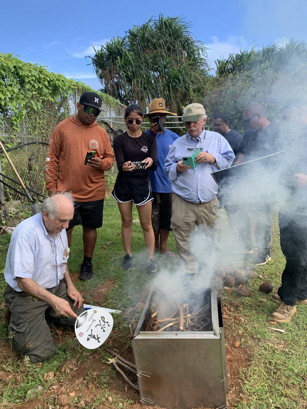 Mohammad Golabi, a University of Guam Land Grant soil, scientist, left, demonstrates biochar production for UOG agriculture students, Photo coutesy of UOG