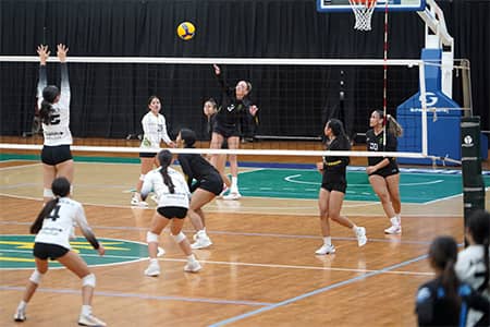 GuamPro1 volleyball player attempts to block spike from opposing team