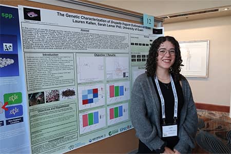 Lauren Kallen poses for photo in front of research presentation