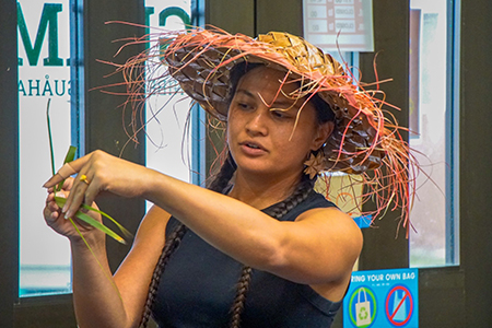 Photo of a female teaching how to weave coconut leaves