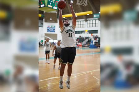 Triton Athlete Isaac Orlando shoots basketball into hoop