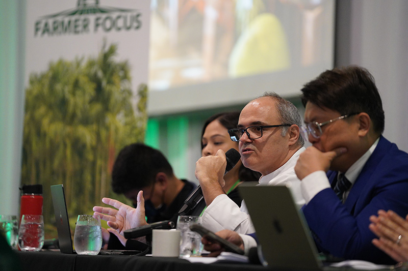 Executive Chef Mirko Agostini of the Hyatt Regency Guam speaks during the Farm-to-Menu expert panel. Four panelists speak in to microphones on a stage