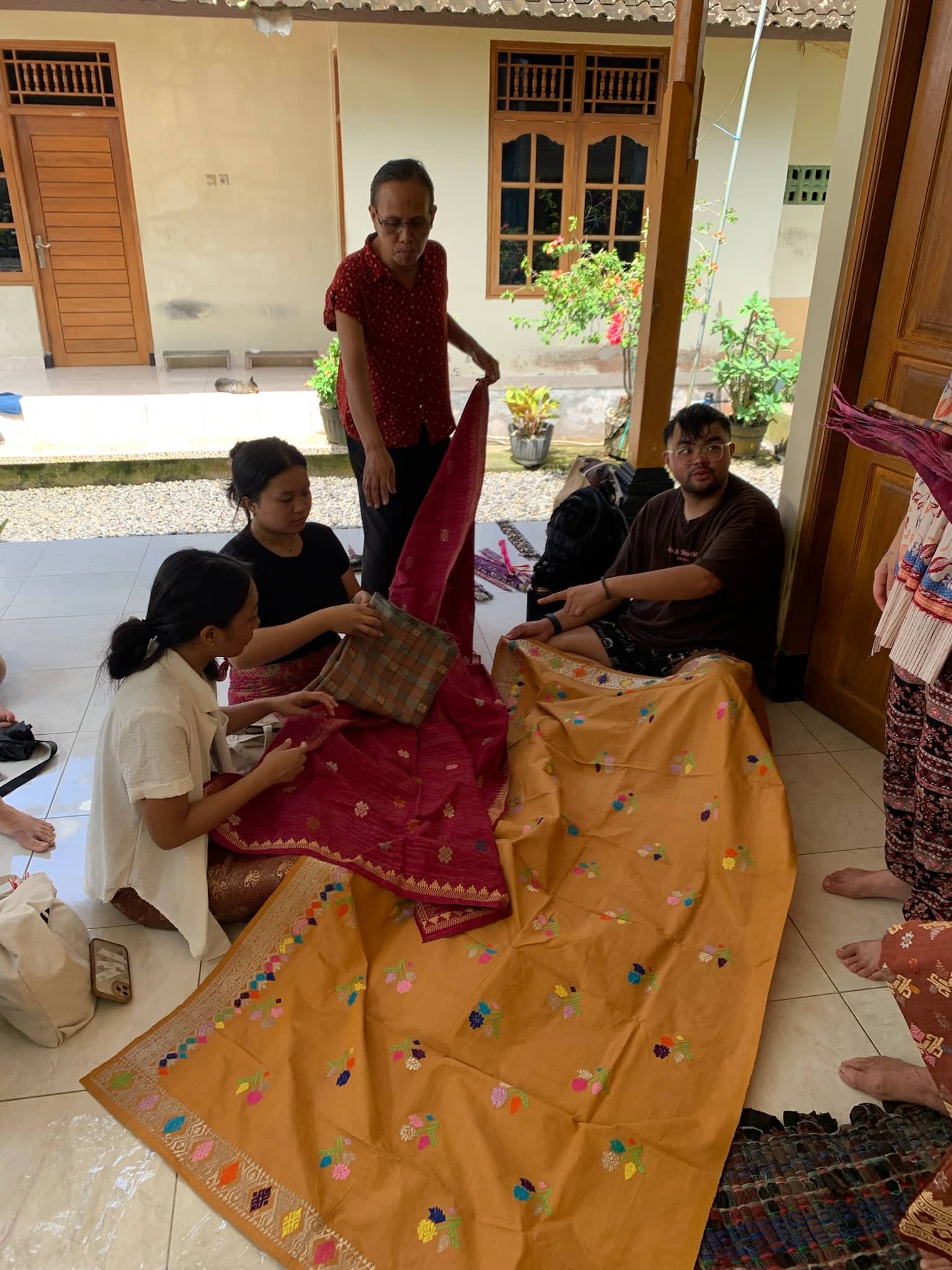 students examine traditional woven textiles