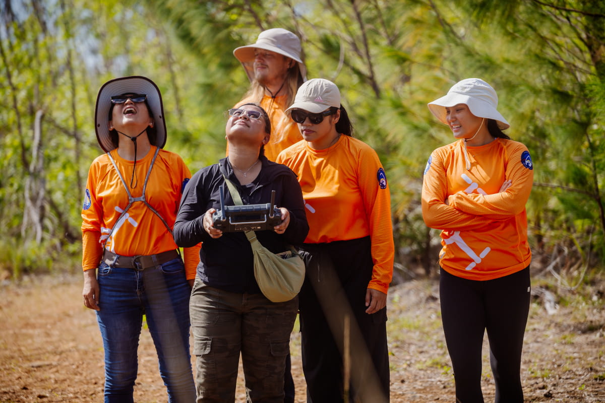 Drone Corps members observe a drone mid-flight